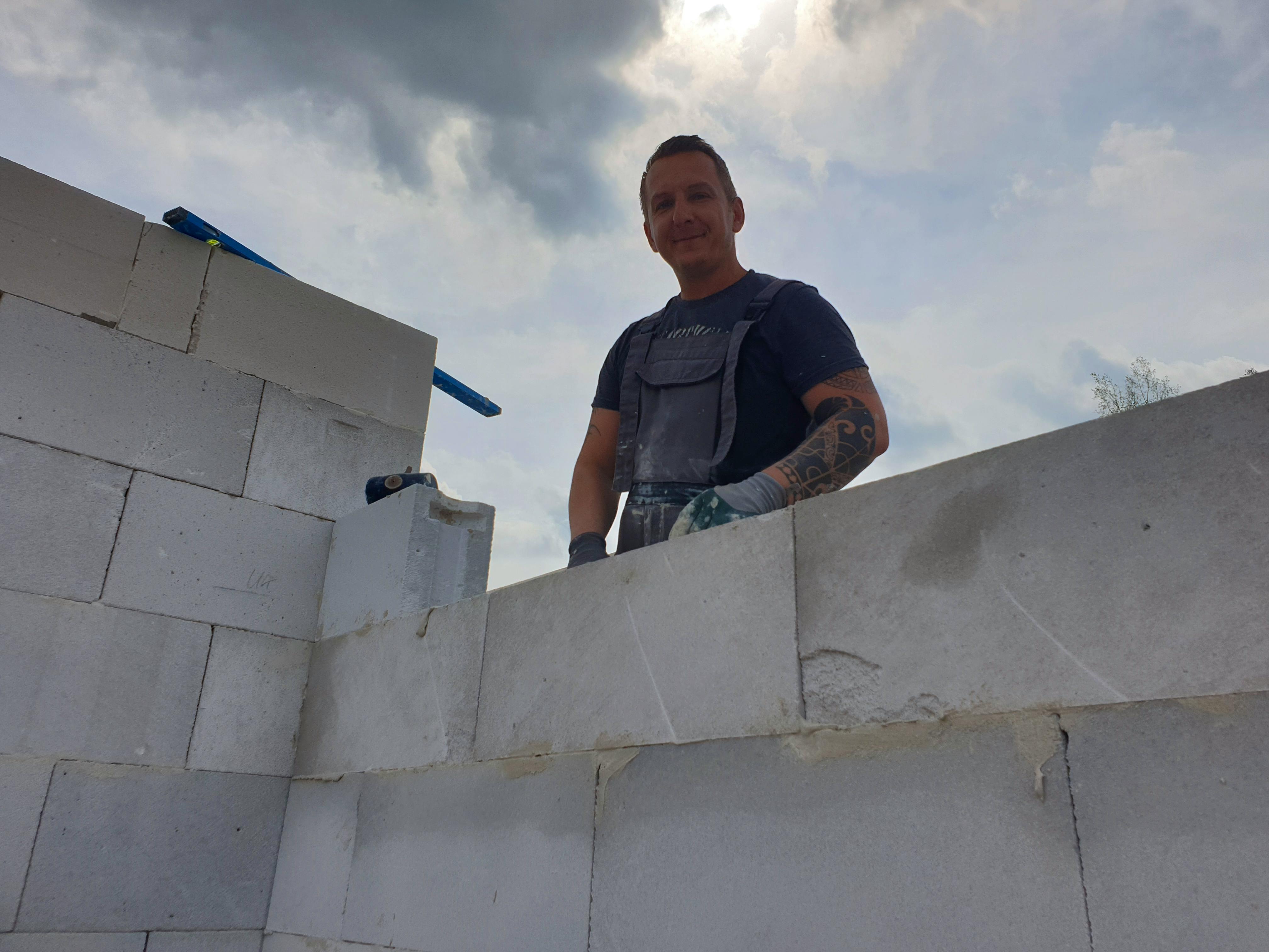 Bauherr beim Mauern der Porenbeton-Wände im Rohbau