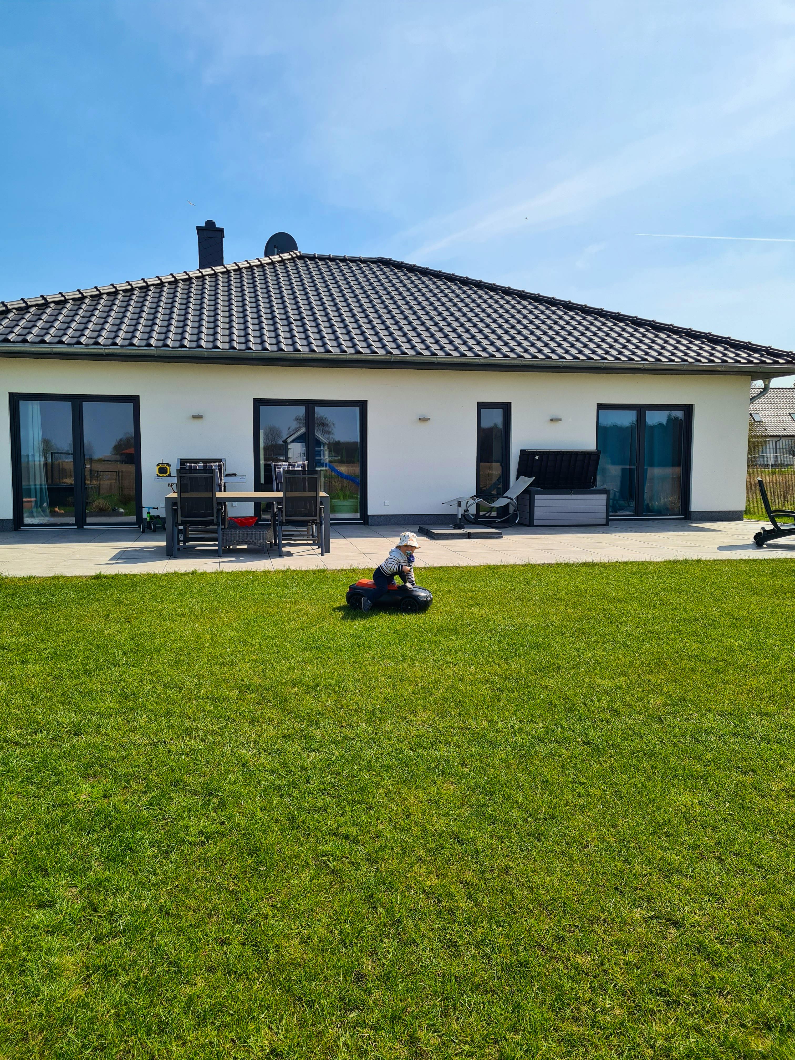 Gartenseite des Bungalows mit durchgehender Terrasse und Rasen
