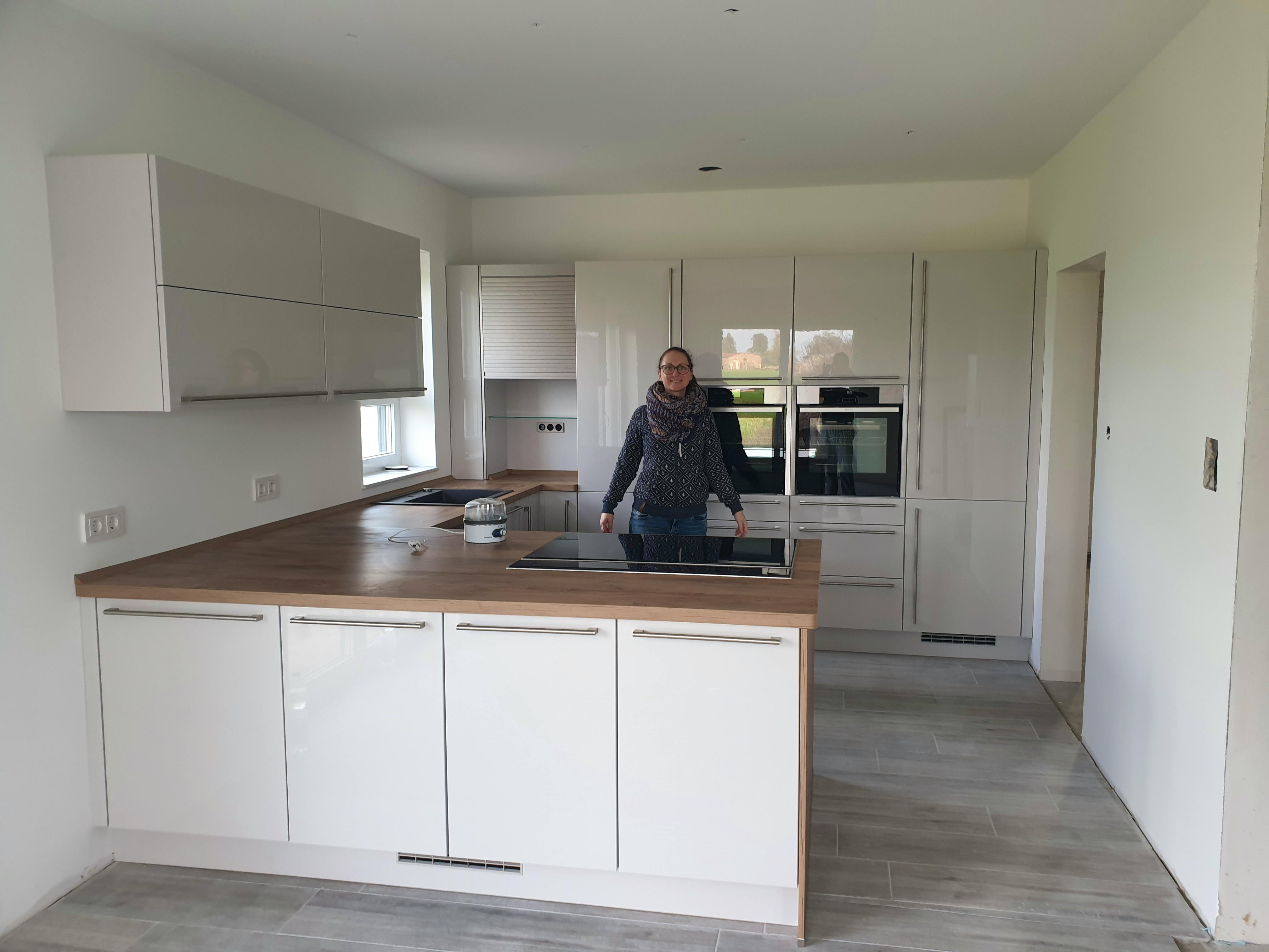 Helle Küche mit Griffen und Holzarbeitsplatte im Bungalow