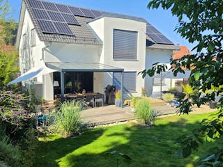 Fertighaus von Hanse Haus mit Terrassenüberdachung, Essbereich und Whirlpool im Garten, Photovoltaikanlage auf dem Süddach