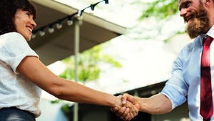 Zwei Menschen gehen einen Deal ein und geben sich freudig die Hand