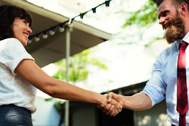 Zwei Menschen gehen einen Deal ein und geben sich freudig die Hand
