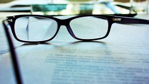 Lesebrille liegt auf einem Bauvertrag