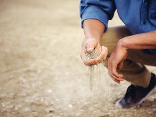 Mann prüft den Sandboden auf Eignung für Hausbau