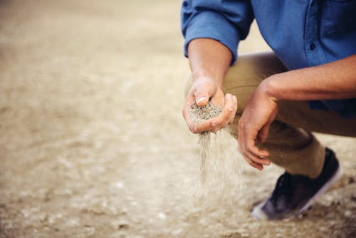 Mann prüft den Sandboden auf Eignung für Hausbau