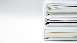 Drei weiße Bücher liegen übereinander