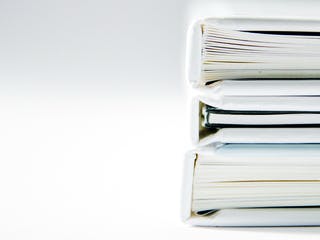 Drei weiße Bücher liegen übereinander