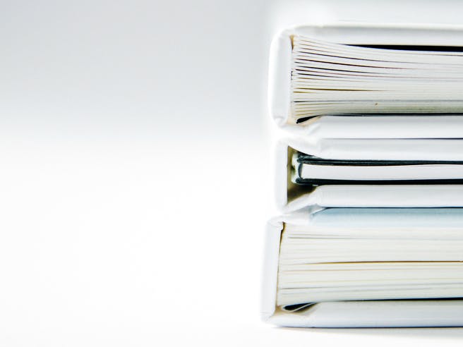 Drei weiße Bücher liegen übereinander