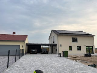 Fertiges Hanse-Haus-Fertighaus mit Satteldach, PV-Anlage auf dem Dach, Doppel-Carport und gepflasterter Zufahrt – Außenanlagen in Eigenleistung.