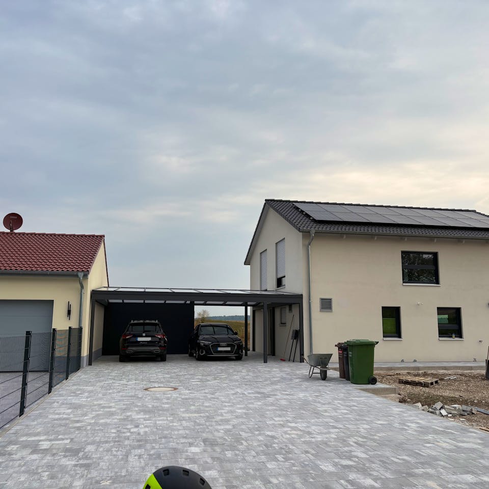 Fertiges Hanse-Haus-Fertighaus mit Satteldach, PV-Anlage auf dem Dach, Doppel-Carport und gepflasterter Zufahrt – Außenanlagen in Eigenleistung.