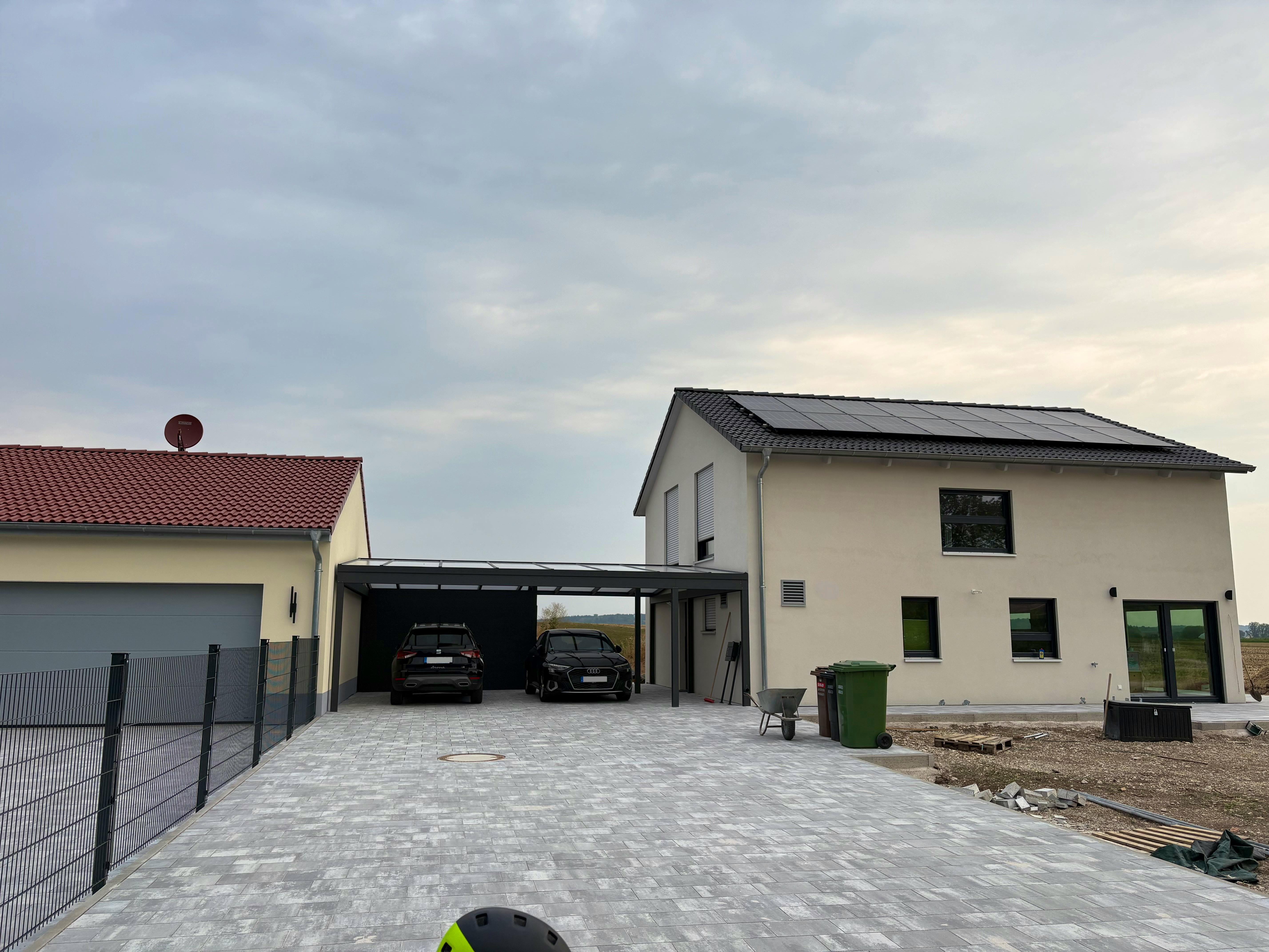 Fertiges Hanse-Haus-Fertighaus mit Satteldach, PV-Anlage auf dem Dach, Doppel-Carport und gepflasterter Zufahrt – Außenanlagen in Eigenleistung.
