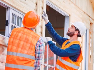 Zwei Männer bauen ein Fenster ein
