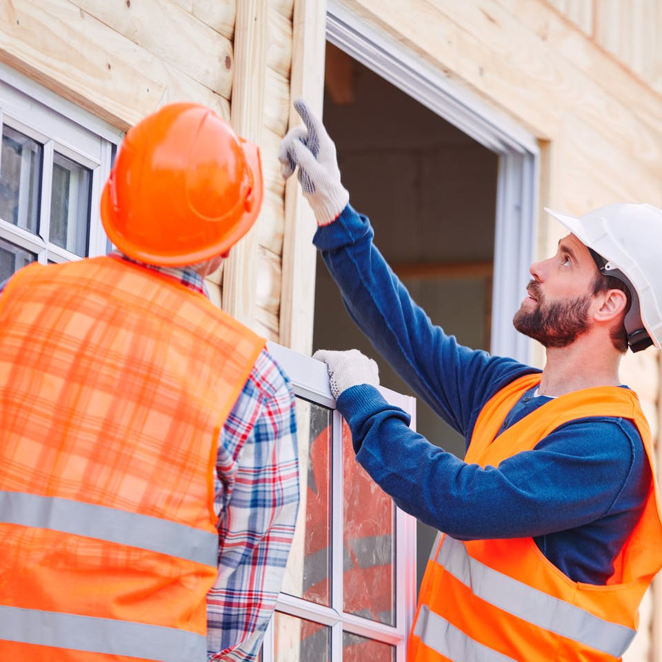 Zwei Männer bauen ein Fenster ein