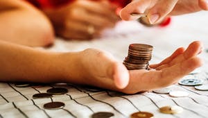 Münzen werden in einer Hand gestapelt um Geld zu zählen