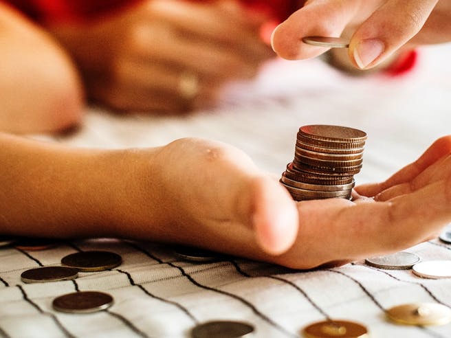 Münzen werden in einer Hand gestapelt um Geld zu zählen