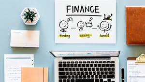 Finanzierungsplanung am Schreibtisch mit Laptop und Schreibmaterial