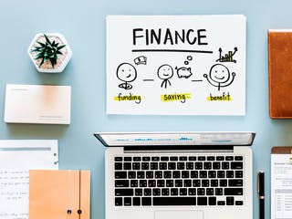 Finanzierungsplanung am Schreibtisch mit Laptop und Schreibmaterial