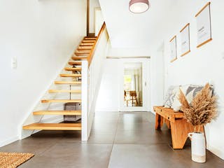 Heller Flur mit Sitzbank und Treppe