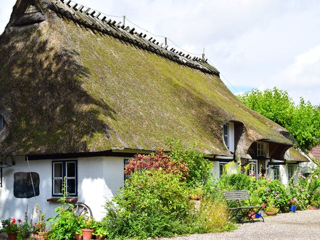 Haus mit Walmdach, das mit Reet gedeckt ist