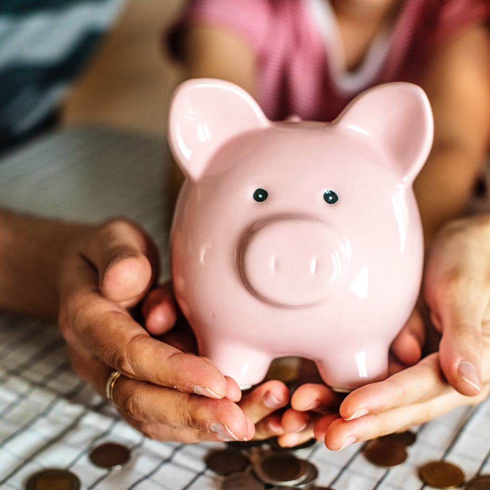 Bauherrenfamilie hält ein Sparschwein in der Hand