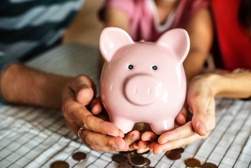 Bauherrenfamilie hält ein Sparschwein in der Hand