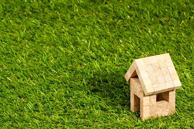 Haus aus Holzklötzen steht auf Rasen