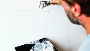 Heimwerker verputzt eine Innenwand im Haus