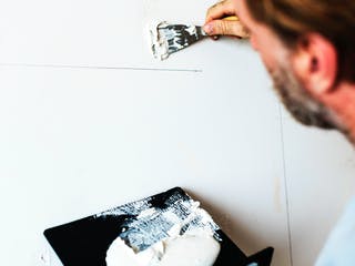 Heimwerker verputzt eine Innenwand im Haus