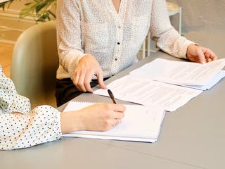 Käufer und Verkäufer geben sich die Hand beim Vertragsabschluss zum Hauskauf