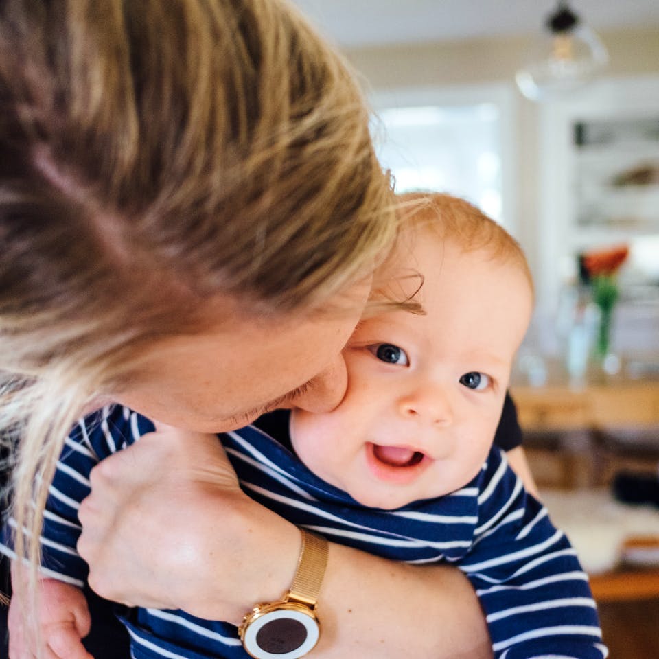 Mutter mit Baby im Arm zu Hause