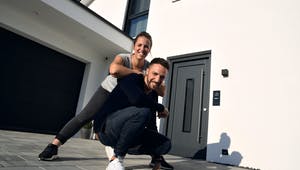Glückliches Bauherrenpaar vor ihrem neuen Living Haus