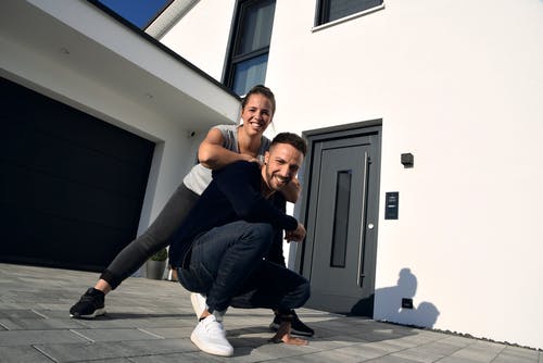 Glückliches Bauherrenpaar vor ihrem neuen Living Haus