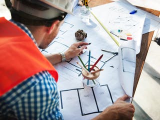 Bauherr zeichnet Grundriss für ein Haus