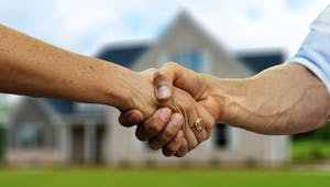 Käufer und Verkäufer geben sich die Hand beim Vertragsabschluss zum Hauskauf