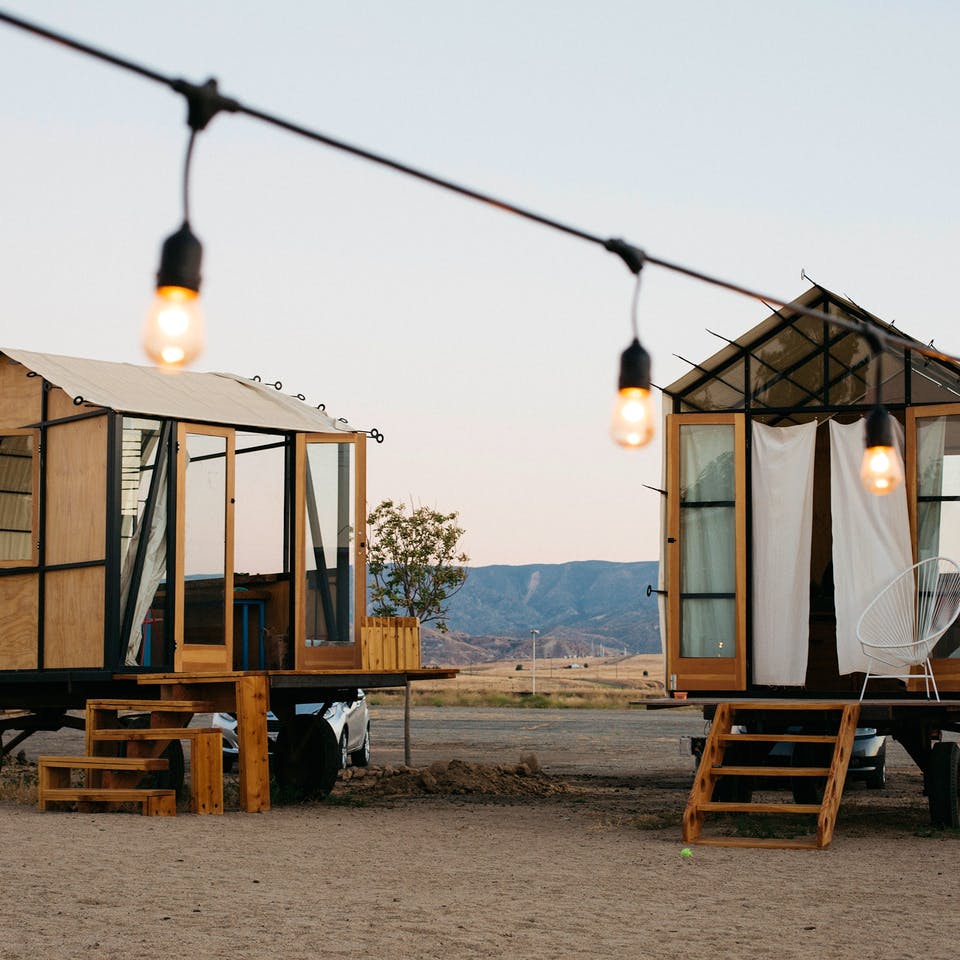 Zwei Tiny Houses aus Holz auf Rädern