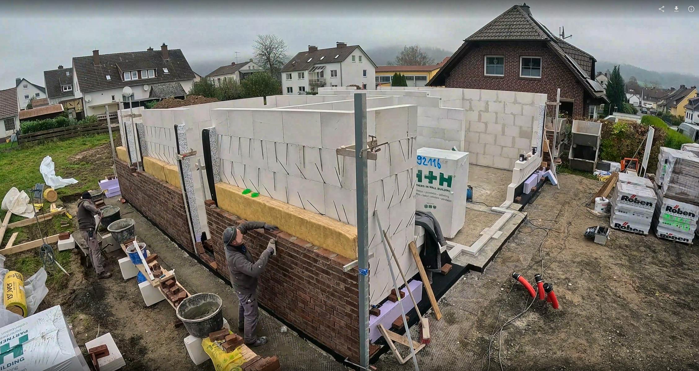 Rohbau der Viebrockhaus-Stadtvilla mit Maurern bei der Klinkerverblendung – Porenbeton-Innenwände und Röben-Klinkerpaletten sichtbar