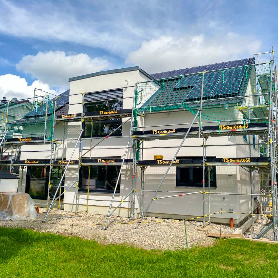 Neubau eines modernen Einfamilienhauses mit Gerüst und Solaranlage auf dem Dach – ein konkretes Bauprojekt einer Baufamilie auf Fertighaus.de