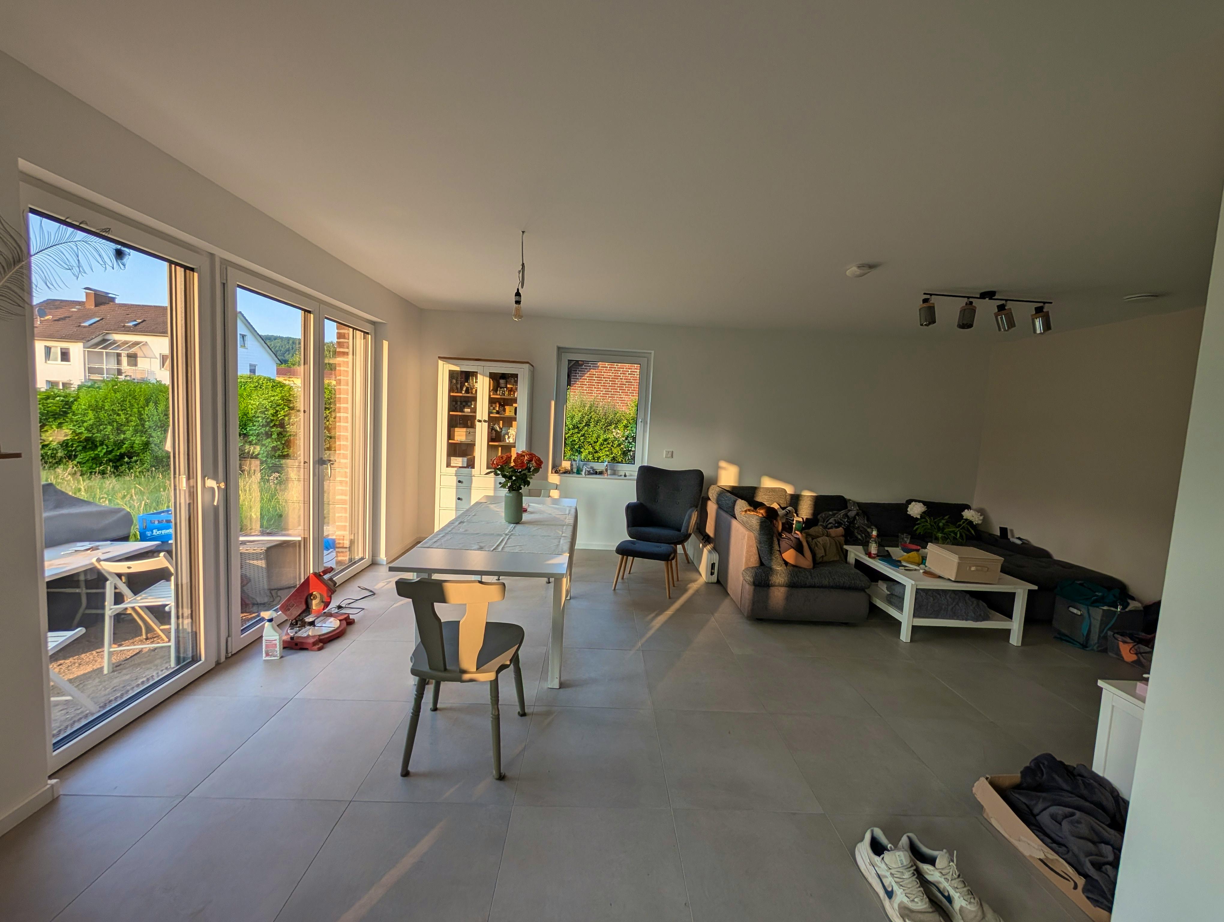 Offener Wohn-Essbereich der Viebrockhaus-Stadtvilla mit bodentiefen Fenstern, Esstisch und Sofa im Tageslicht