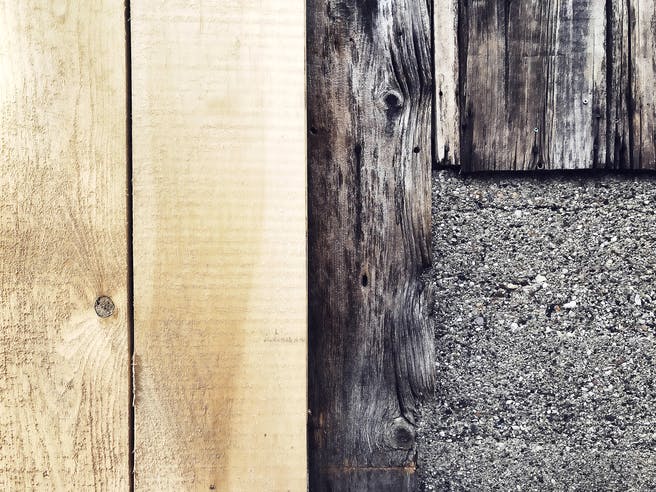 Neue Holzverkleidung neben einer alten Holzfassade