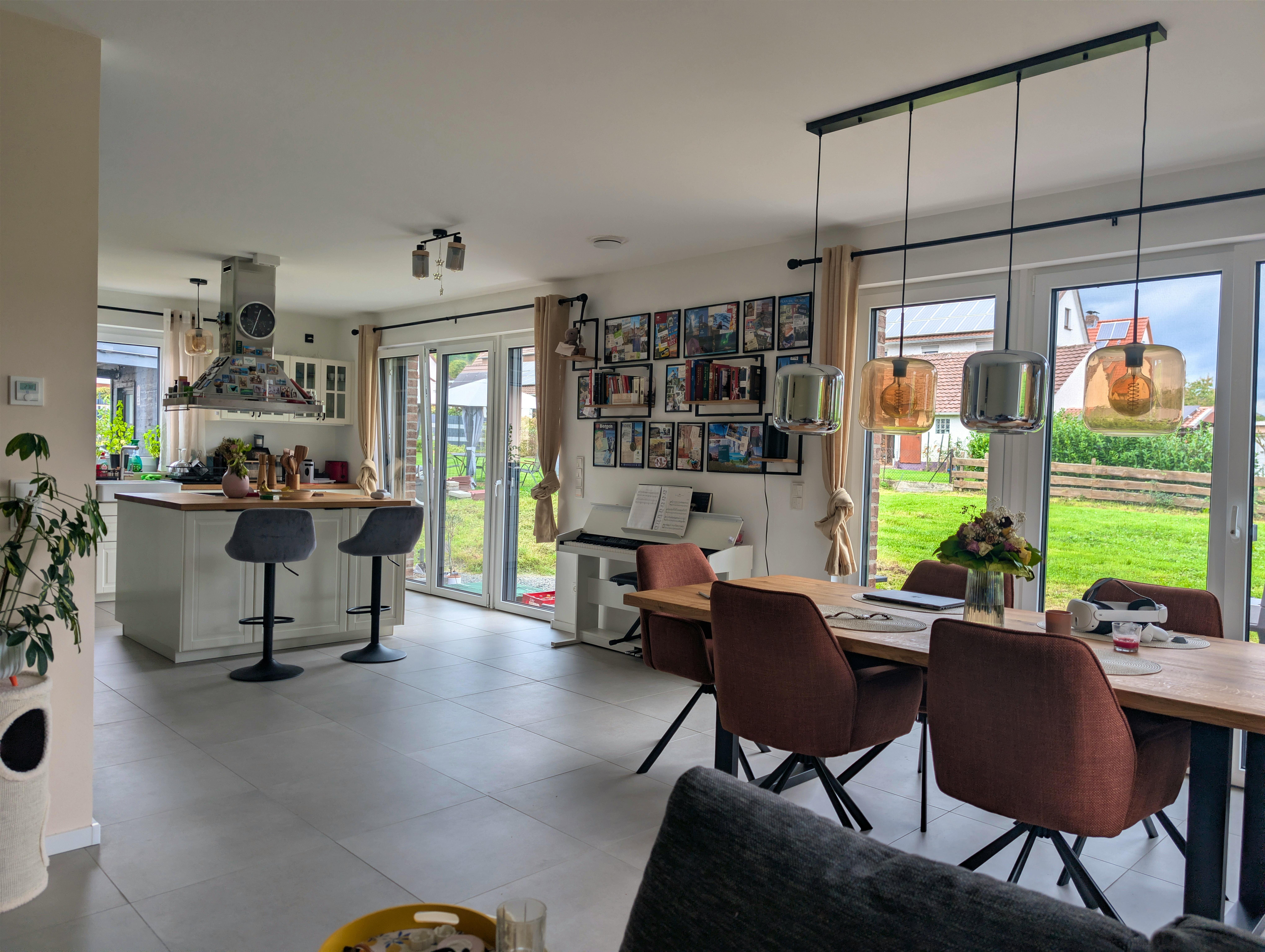 Offener Wohn-Essbereich der Viebrockhaus-Stadtvilla mit bodentiefen Fenstern, Esstisch und Sofa im Tageslicht