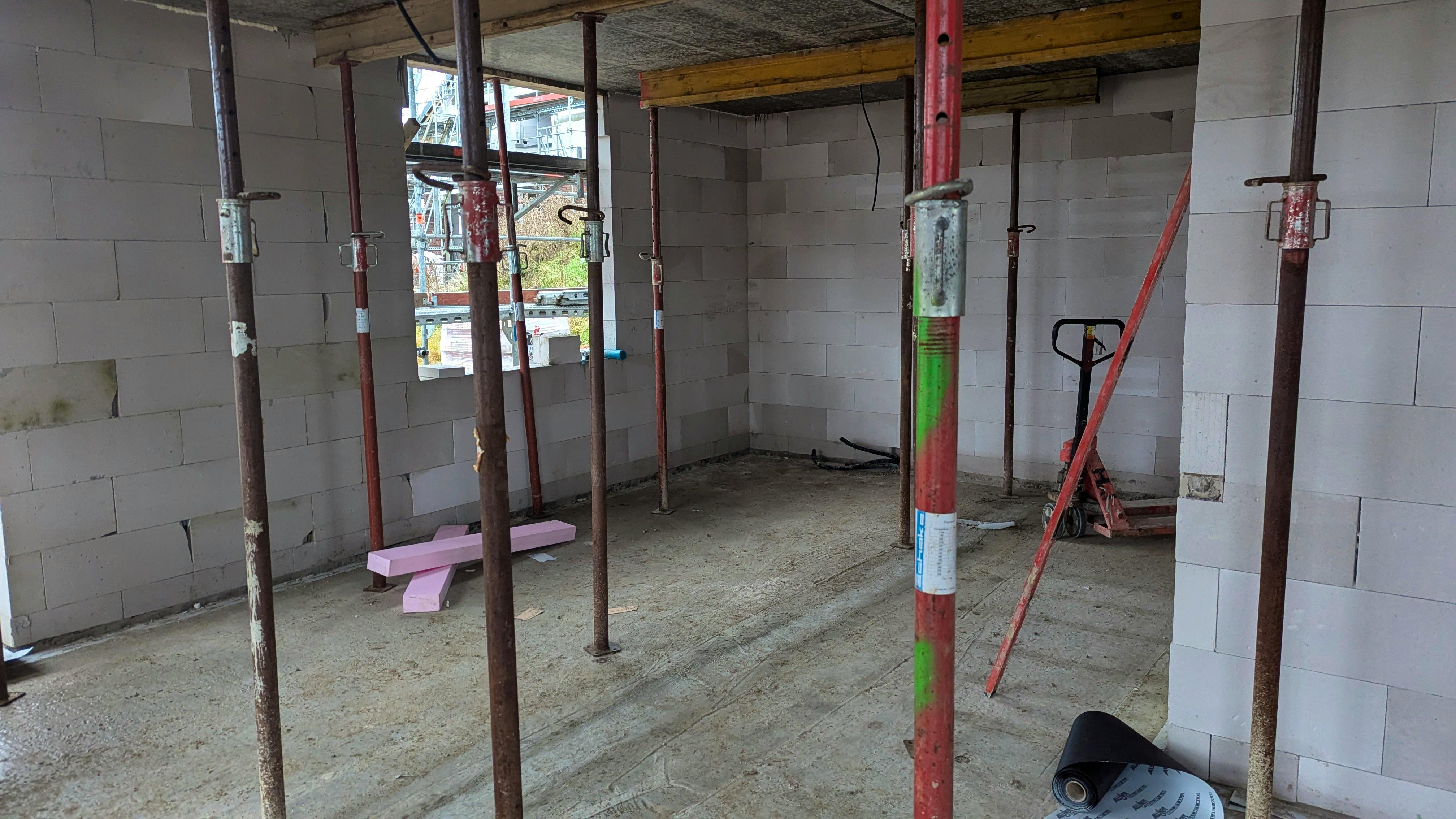 Rohbau-Innenraum mit Porenbeton-Wänden und Baustützen unter der Geschossdecke