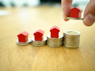 Kleine Häuschen auf gestapelten Euro Münzen