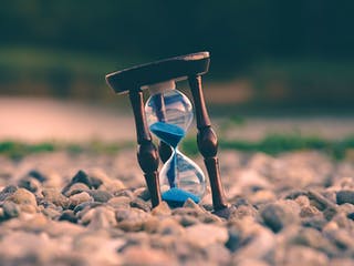 Laufende Sanduhr auf Kieselsteinen