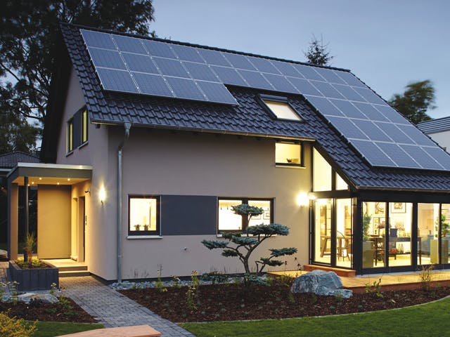 Helles Haus mit Schleppdach und Solarzellen