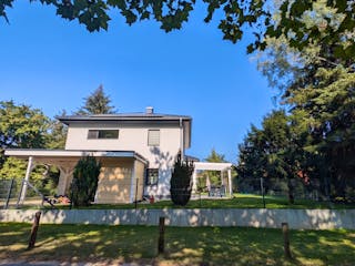 Fertige Stadtvilla bei Berlin mit Carport, Terrassenüberdachung und gepflegtem Garten im Sommer – Bauerfahrung Massivhaus Berliner Umland