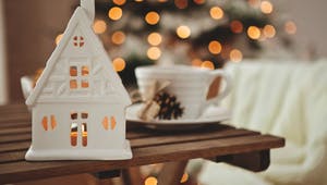 Weißes Teelichthaus vor Weihnachtsbaum