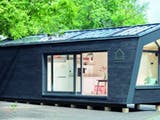 Sehr kleines Haus in Containerform mit schwarzer Holzfassade
