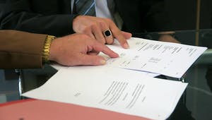 Zwei Menschen prüfen einen Kaufvertrag