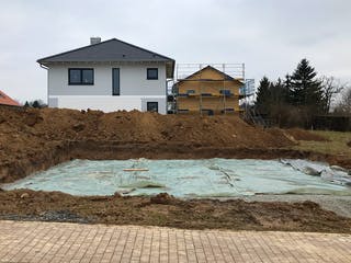 Ausgehobene Baugrube für Hausbau mit Plane bedeckt