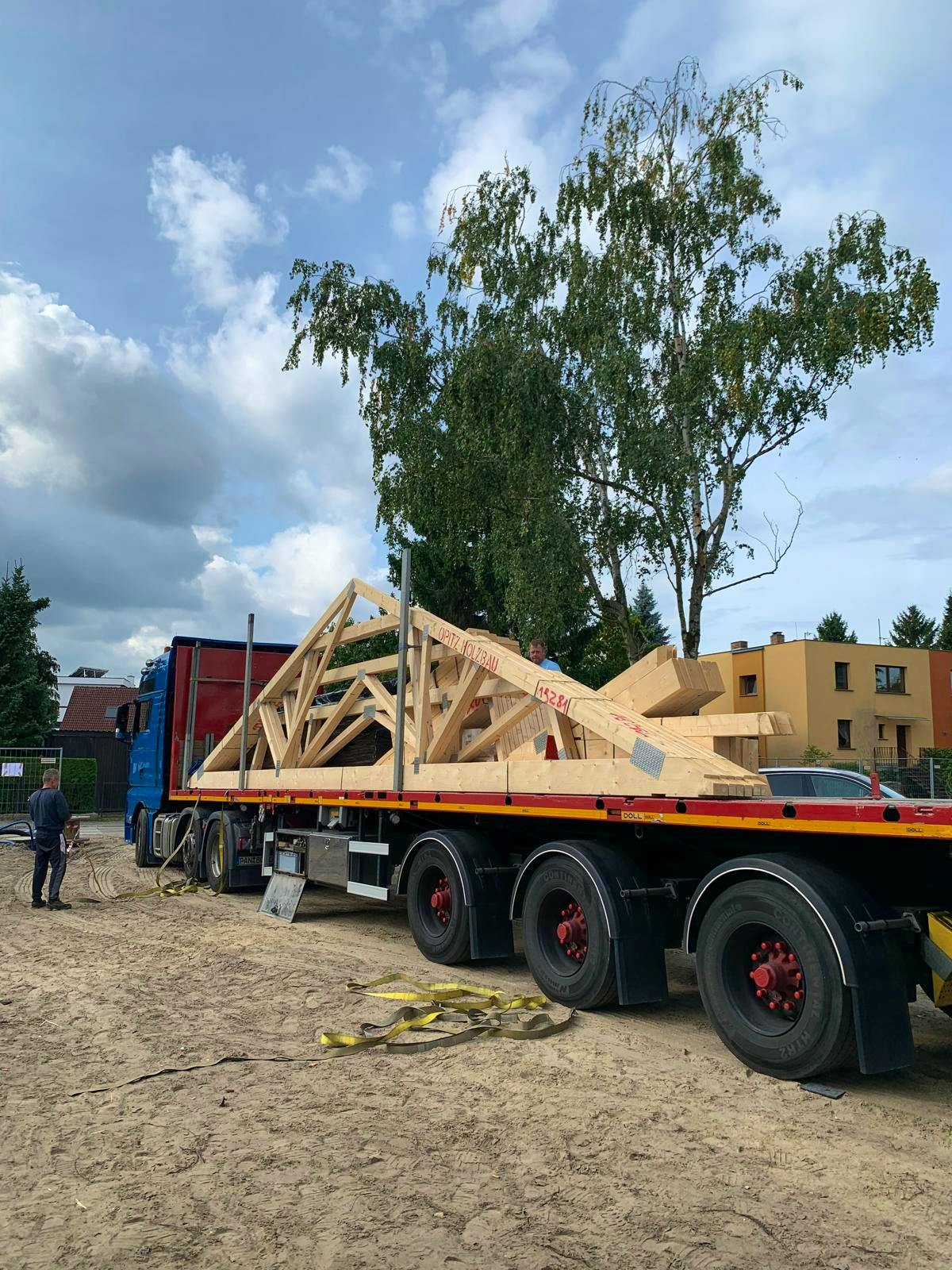Vorgefertigter Dachstuhl aus Holz auf einem Tieflader-LKW vor der Anlieferung an die Baustelle in Berlin